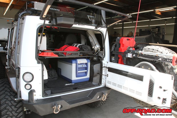 Inside the rear tailgate, a Garmin rack provides extra storage space for the two 1-gallon RotoPax water holder, the Viair tank and backup Powertank. Aside from tools, an ARB fridge is also fitted in the rear for extended trips.