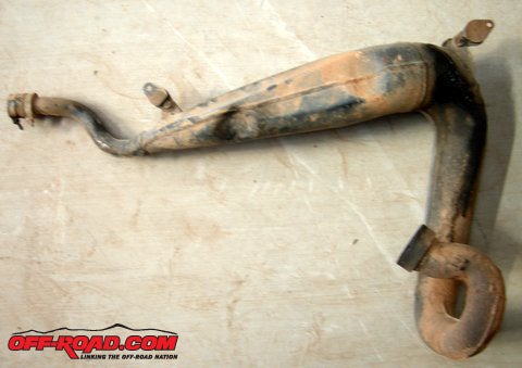 The complete pipe can now be removed and checked for cracks or bad dents.  Luckily, the exhaust on our YZ250 was in pretty good shape aside from a light surface rust and a coating of crud.
