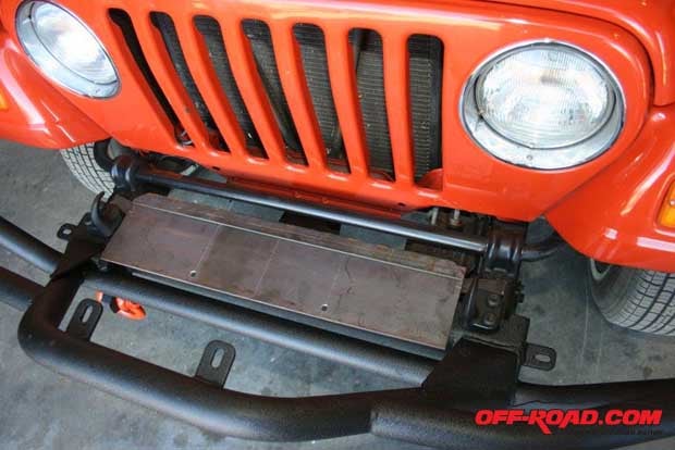 With the frame fails and sway bar painted, we bolted on the front bumper and tow hooks (the steel shim is beneath the tow hooks). The fit of the winch plate was tested.